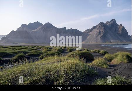 Plage de lave noire, plage de sable, dunes avec herbe sèche, montagnes Klivatindur, Eystrahorn et Kambhorn, promontoire Stokknes, chaîne de montagnes Klivatindur Banque D'Images