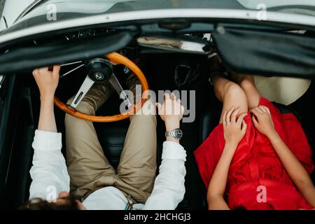 Vue de dessus d'un jeune couple dans un cabriolet d'époque Banque D'Images