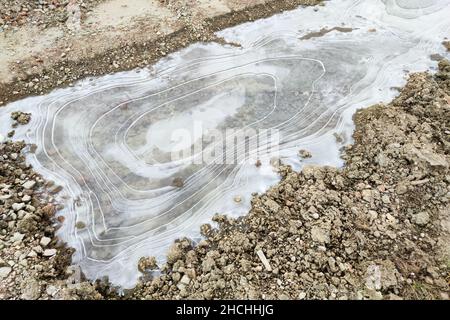 Anneaux de forme ovale dans la glace d'un bas de porte surgelé.Phénomène physique. Banque D'Images