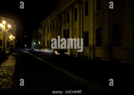 Rue pavée dans une ville italienne la nuit avec la façade d'un château Banque D'Images