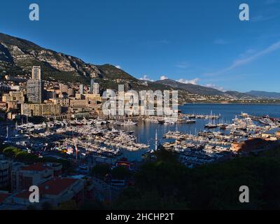 Belle vue panoramique de la Principauté de Monaco au soleil de l'après-midi avec port de plaisance Port Hercule, foire et immeubles de haute hauteur. Banque D'Images