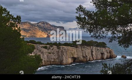 Vue sur les falaises escarpées du massif des Calanques près de Cassis, Côte d'Azur sur la côte méditerranéenne avec arbres et Cap Canaille. Banque D'Images