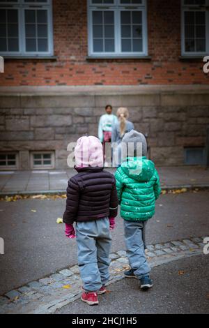 Prise de vue verticale d'enfants jouant à la lumière rouge, lumière verte du match de calamar à Oslo, Norvège Banque D'Images