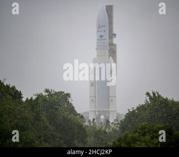 Kourou, Guyane française.23rd décembre 2021.La fusée Ariane 5 d'Arianespace, avec le télescope spatial James Webb de la NASA, est déployée sous la pluie jusqu'au plateau de lancement d'Europes Spaceport, le Centre spatial de la Guyane à Kourou, en Guyane française.Le télescope spatial James Webb (parfois appelé JWST ou Webb) est un grand télescope infrarouge doté d'un miroir primaire de 21,3 pieds (6,5 mètres).L'observatoire étudiera chaque phase de l'histoire cosmique'''', de l'intérieur de notre système solaire aux galaxies observables les plus lointaines du début de l'univers.Credit: Bill Ingalls/NASA/ZUMA Press Wire Service/ZUMAPRESS.com/Alamy Live News Banque D'Images