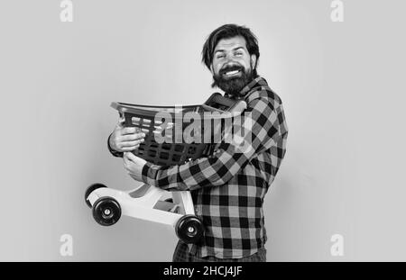 l'homme brutal en chemise à carreaux a une longue barbe chariot de transport, le vendredi noir Banque D'Images