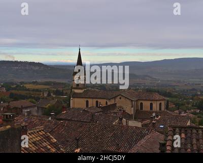 Belle vue sur le centre du petit village de Bonnieux dans la chaîne de montagne Luberon en Provence, France par jour nuageux en automne avec des bâtiments typiques. Banque D'Images