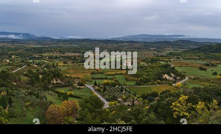 Belle vue panoramique sur la vallée du Luberon près du village de Gordes, Frence en Provence en automne avec arbres colorés et vignobles par temps nuageux. Banque D'Images