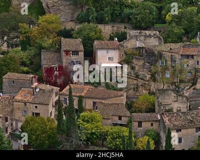 Vue rapprochée de maisons historiques construites en pierre entre rochers sur une colline dans le petit village de montagne Gordes, France dans la vallée du Luberon en Provence. Banque D'Images