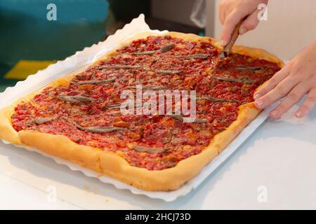 Couper un coca traditionnel alicantina avec de la ratatouille et des anchois Banque D'Images