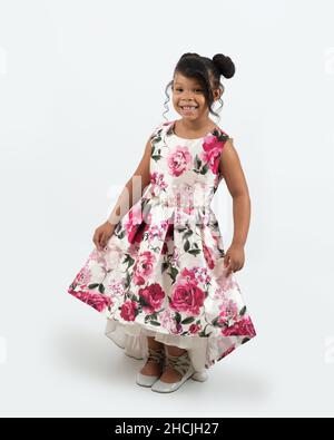 portrait de pleine longueur de fille de 4 ou 5 ans, souriant, fond blanc, en robe habillée Banque D'Images