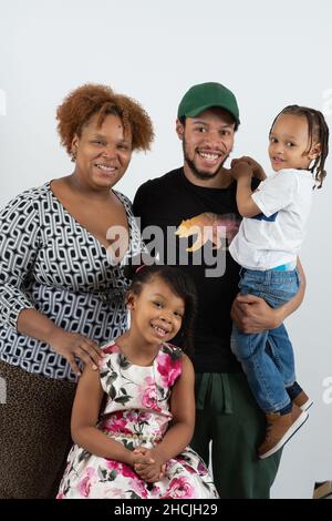 Gros plan portrait d'une fille de 4 ou 5 ans, simling, avec mère, père et frère de 3 ans, portrait de famille sur fond blanc Banque D'Images
