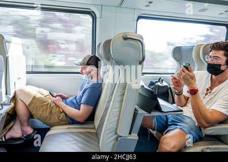 Fort ft. Lauderdale Florida Brightline service de transport ferroviaire de voyageurs cabine de transport de masse à l'intérieur sièges homme lecture smartphon Banque D'Images