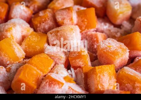 Des morceaux de cube de carottes fraîches surgelées ferment l'arrière-plan Banque D'Images