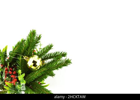 Boule de Noël jouet décoration à facettes couleur dorée sur branche de sapin isolée sur fond blanc Banque D'Images