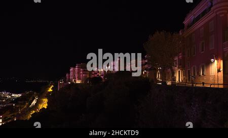 Belle vue nocturne des anciens bâtiments illuminés du centre historique de Monaco (Monaco-ville) sur la Côte d'Azur avec arbres. Banque D'Images