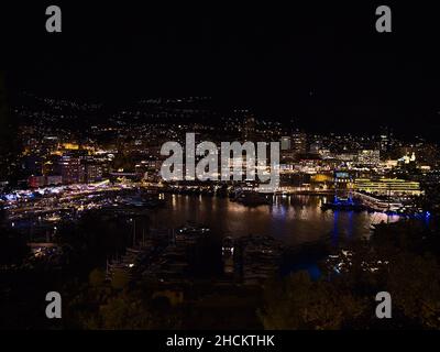 Superbe vue nocturne du centre de Monaco sur la côte méditerranéenne avec foire et yacht amarrés dans la marina Port Hercule avec des bâtiments. Banque D'Images