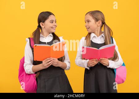 Apprendre pour la vie.Les enfants heureux lisent des livres sur fond jaune.Faire de l'apprentissage Banque D'Images