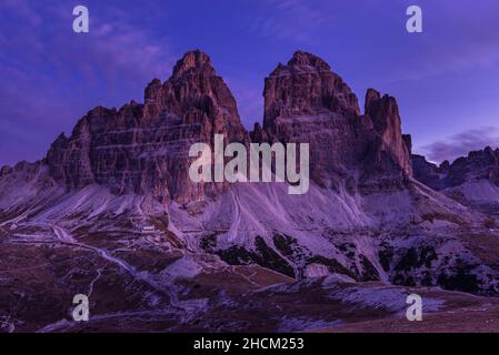 La cabane Auronzo et les parois rocheuses du sud des trois sommets Tre Cime di Lavaredo brillent à l'aube en automne, Sexten Dolomites, Belluno, Italie Banque D'Images