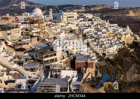 Fira, Santorini, Grèce - 27 juin 2021 : la ville blanchie à la chaux de Fira dans des rayons chauds de coucher de soleil sur l'île de Santorini, Cyclades, Grèce Banque D'Images