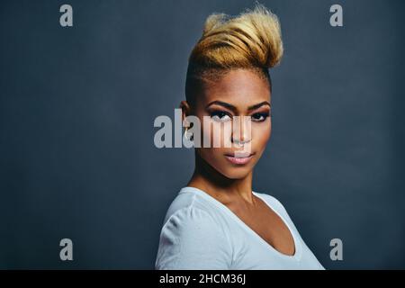 Portrait d'une jeune femme très confiante avec des cheveux courts frais et volumineux, un anneau de nez et des boucles d'oreilles tendance Banque D'Images