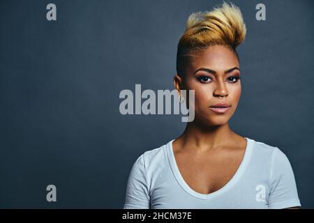 Portrait d'une jeune femme très confiante avec des cheveux courts frais et volumineux, un anneau de nez et des boucles d'oreilles tendance Banque D'Images