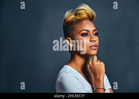 Portrait d'une jeune femme très confiante avec des cheveux frais et court volumineuse anneau de nez tendance pensant et regardant à côté Banque D'Images