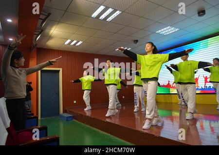 (211230) -- NANCHANG, 30 décembre 2021 (Xinhua) -- Fan Haiyan (1st L) et ses élèves répètent danser à l'école d'éducation spéciale de la ville de Yichun, dans la province de Jiangxi, dans l'est de la Chine, 28 décembre 2021.Fan Haiyan, enseignante de l'école d'éducation spéciale de la ville de Yichun, a appris la langue des signes dans son temps libre pour améliorer son enseignement des élèves ayant une déficience auditive.Après des années de pratique, Fan pouvait transmettre rapidement et correctement le message à ses élèves lors de la création de chorégraphies ou de répétitions de routines de danse.Fan et ses élèves ont participé à de nombreux concours d'art ces années, par l'intermédiaire de wh Banque D'Images