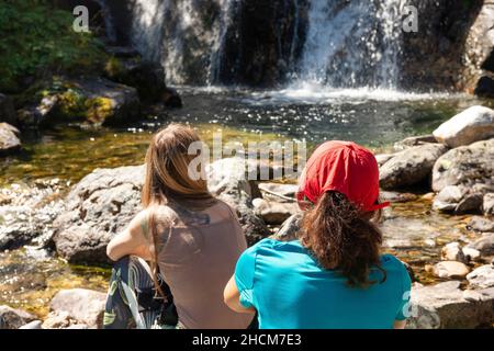 Randonneuses par une petite cascade de rivière de montagne dans la montagne Rila, Bulgarie, Europe de l'est, Balkans, UE Banque D'Images