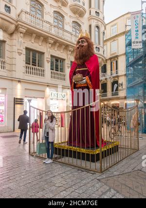 Jeune fille devant la statue géante de Saint Melchior une des trois Rois célébration, Malaga, Andalousie, Espagne. Banque D'Images