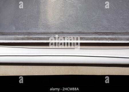 toit en feuilles en acier inoxydable, tuyau d'évacuation d'eau de pluie blanc gouttière sur le bâtiment en gros plan, personne. Banque D'Images