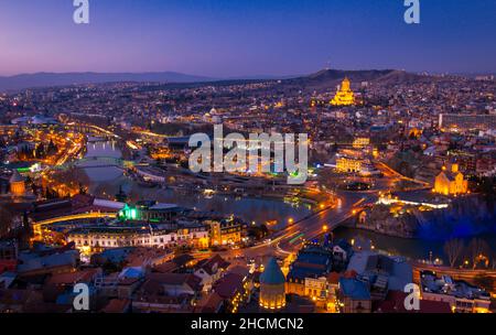 Vue panoramique sur la ville de Tbilissi depuis la forteresse de Narikala après le coucher du soleil pendant l'heure bleue.Sentiers de circulation et concept romantique de Géorgie.2020 Banque D'Images