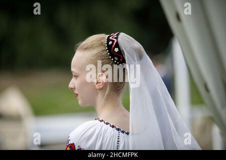 Braila, Roumanie - 26 août 2021:profondeur de champ peu profonde (foyer sélectif) détails avec une fille vêtue de vêtements traditionnels roumains. Banque D'Images