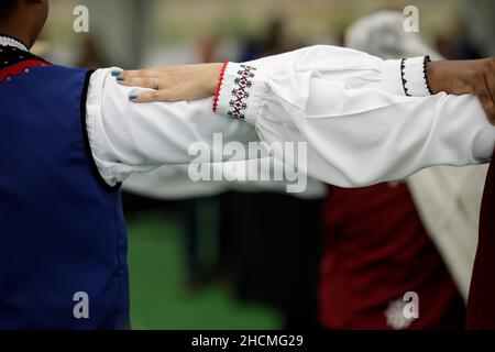 Braila, Roumanie - 26 août 2021 : des hommes et des femmes vêtus de costumes traditionnels roumains exécutent une danse traditionnelle. Banque D'Images