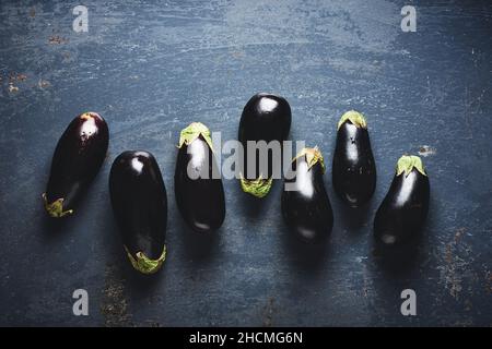 Aubergines fraîches sur fond bleu, vue du dessus. Banque D'Images