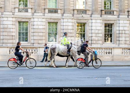 Policiers sur chevaux et cyclistes à louer vélos Santander à Whitehall, Londres, Royaume-Uni Banque D'Images