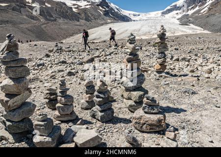 Les randonneurs passent par le cairn rocheux marquant le bord de l'immense champ de glace Columbia et du glacier Athabasca, à l'extrémité sud du parc national Jasper, en Alberta, au Canada.Le champ de glace Columbia est le plus grand champ de glace des montagnes Rocheuses. Banque D'Images