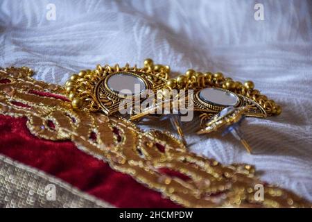 Photo de stock de beaux bijoux indiens miroir doré zumka ou boucle d'oreille sur fond blanc.bijoux traditionnels indiens tendance, se concentrer sur l'objet à Banga Banque D'Images