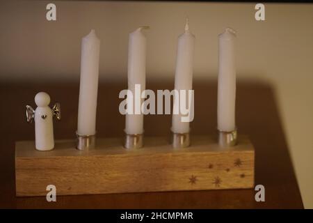 Mise au point peu profonde d'un ensemble de bougies blanches et d'un décor de Noël ange sur une table en bois Banque D'Images