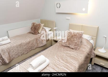 Kazimierz Dolny, Pologne.29 décembre 2021.Chambre d'hôtel moderne avec lits jumeaux et serviettes de toilette fraîches sur les lits Banque D'Images