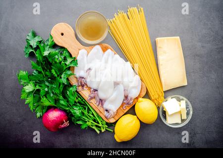 Vue de dessus de Squid Piccata Ingrédients: Tubes et tentacules de calmar crus, pâtes linguine nouilles, et autres ingrédients de picata Banque D'Images