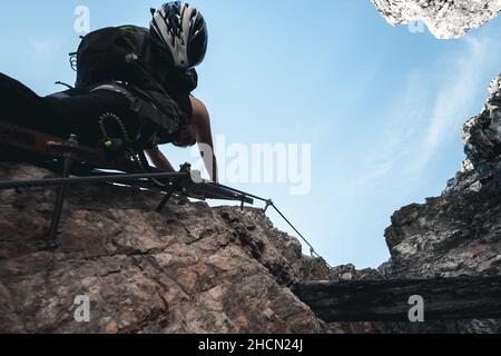 Une jeune fille monte une lettre via ferrata sur une montagne massive au Toblinger Knoten dans les Dolomites, en Italie Banque D'Images