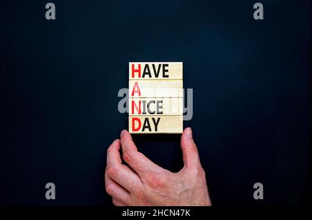 MAIN ont un joli symbole de jour.Concept mots MAIN ont une belle journée sur des blocs de bois.Belle table noire, fond noir.Main d'homme d'affaires.Entreprise Banque D'Images