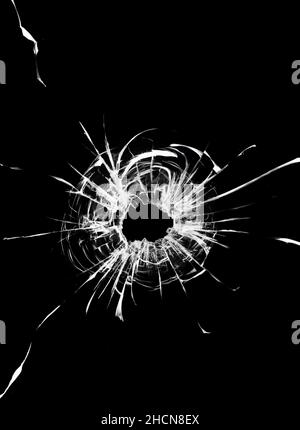 L'effet des fissures et des trous de balle sur la vitre.Vitre de voiture cassée.Cliché d'une arme dans le pare-brise Banque D'Images