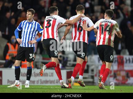 Callum Doyle de Sunderland (au centre) célèbre le troisième but de son équipe avec Tom Flanagan et Ross C Stewart (à droite), alors que Ciaran Brennan (à gauche) de Sheffield Wednesday, regarde pendant le match Sky Bet League One au stade de Light, Sunderland.Date de la photo: Jeudi 30 décembre 2021. Banque D'Images