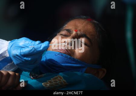 New Delhi, Inde.30th décembre 2021.Un travailleur de la santé recueille un échantillon d'écouvillonnage de la maladie du coronavirus (COVID-19) auprès d'un passager au milieu de la propagation de la maladie, dans une gare ferroviaire.(Credit image: © Karma Sonam Bhutia/ZUMA Press Wire) Banque D'Images