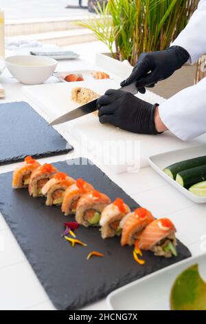 Chef masculin dans l'avocat de peeling uniforme pour sushi Banque D'Images