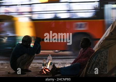 New Delhi, New Delhi, Inde.30th décembre 2021.Un couple se réchauffe par un feu le long d'une route lors d'une nuit froide d'hiver.(Credit image: © Karma Sonam Bhutia/ZUMA Press Wire Service) Banque D'Images