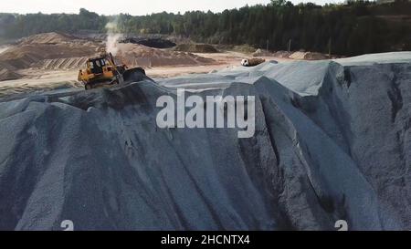 Vue aérienne du convoyeur du site d'extraction de sable avec équipement professionnel au travail.Vol au-dessus d'une carrière de pierres avec des camions et des machines lourds en fonctionnement. Banque D'Images