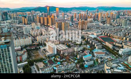 KUNMING, CHINE - 30 DÉCEMBRE 2021 - la photo aérienne prise le 30 décembre 2021 montre un paysage urbain spectaculaire au coucher du soleil à Kunming, dans la province du Yunnan, en Chine. Banque D'Images