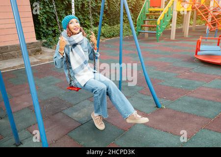 Ininfantile et childish Happy Woman ou une adolescente balance sur la seesaw.Concept de psychologie et de sociologie de la nouvelle génération et de grandir. Banque D'Images